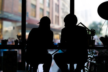 Shadow of couple sitting in coffee shop and looking out of windows.