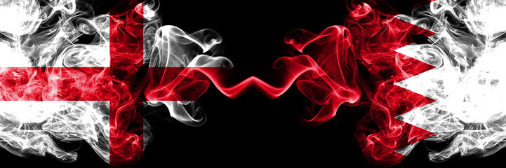 English vs Bahrain, Bahrani smoky mystic flags placed side by side. Thick colored silky smokes flag of England and Bahrain, Bahrani.