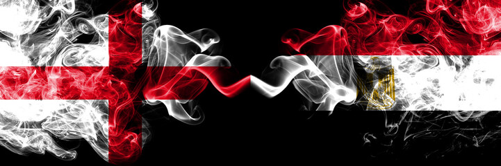 Fototapeta premium English vs Egypt, Egyptian smoky mystic flags placed side by side. Thick colored silky smokes flag of England and Egypt, Egyptian.