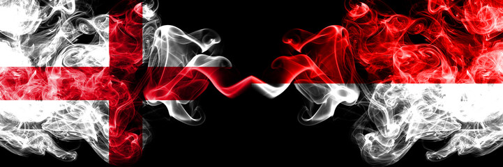 English vs Indonesia, Indonesian smoky mystic flags placed side by side. Thick colored silky smokes flag of England and Indonesia, Indonesian.