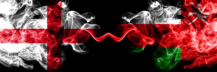 English vs Oman, Omani smoky mystic flags placed side by side. Thick colored silky smokes flag of England and Oman, Omani.