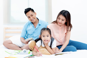 Asian people, Happy family in bedroom at home. Mother, Father and the children playing, Activities of family members are good family health of three people Education of kids, Health Insurance concept.