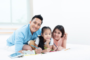 Asian people, Happy family in bedroom at home. Mother, Father and the children playing, Activities of family members are good family health of three people Education of kids, Health Insurance concept.