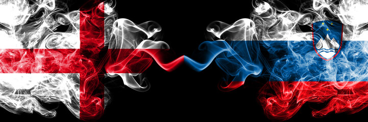 English vs Slovenia, Slovenian smoky mystic flags placed side by side. Thick colored silky smokes flag of England and Slovenia, Slovenian.