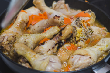 chicken legs are cooked in a pan
