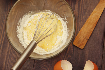 Making dough for baking from fresh ingredients on a rustic table.