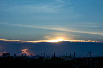 A sunset image with a cloud divides the line between the center of the image with the background