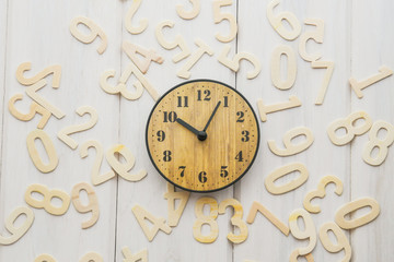 Concept clock and numbers on a white wooden table