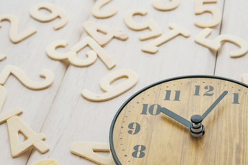 Concept clock and numbers on a white wooden table