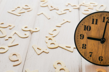 Concept clock and numbers on a white wooden table