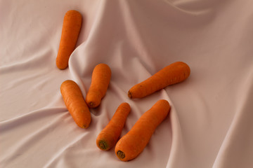 Group of beautiful carrots on a white fabric background