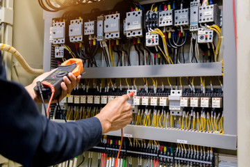 Electrician engineer work  tester measuring  voltage and current of power electric line in...