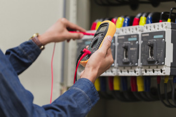 Electrician engineer work  tester measuring  voltage and current of power electric line in...
