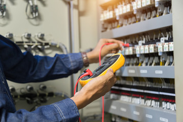 Electrician engineer work  tester measuring  voltage and current of power electric line in...