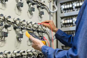 Electrician engineer work  tester measuring  voltage and current of power electric line in...