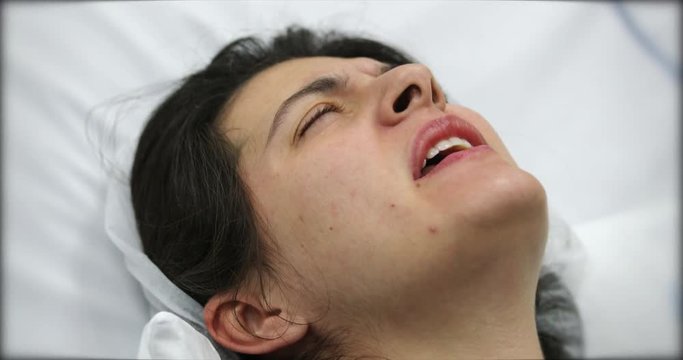 Woman in pain at the hospital, real life woman suffering