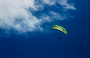 Two paraglider tandem fly against the blue sky,tandem paragliding guided by a pilot
