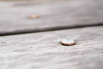 old rusted carriage bolt in wood table.