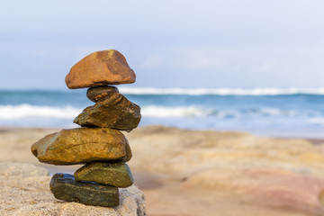 Fototapeta na wymiar balanced sea rocks with the ocean blurred in the background