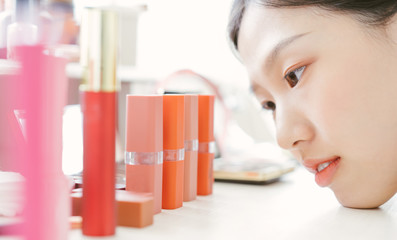 Asian woman deciding to choose lipstick