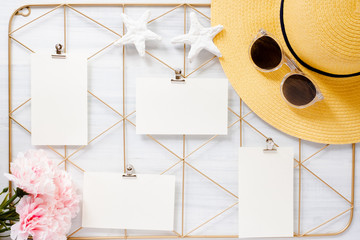 Top view set of note pad clip frame and summer hat with flower on white wood table.summer vacation background