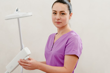 Female cosmetologist using modern equipment for facial peeling