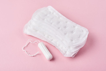Sanitary pad and menstrual tampon on a pink background