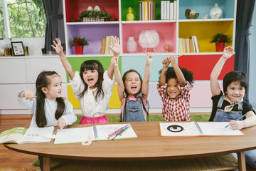 Group of little preschool kids hands up in class . portrait of children diversity education concept.