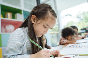 little preschool kids drawing paper with color pencils . portrait of girl with friends education concept.