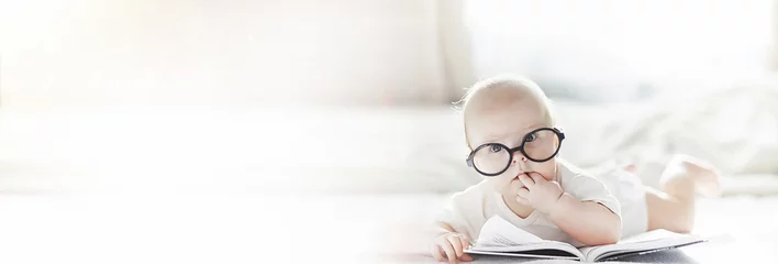Fototapete Tagesbetreuung Ein neugeborenes Baby liegt in einer Brille auf einem weichen Bett.