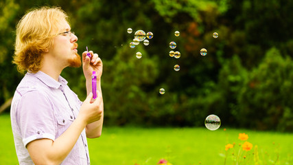 Man blowing soap bubbles outdoor