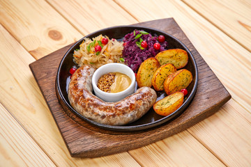sausage with baked potatoes and salad on the wooden background