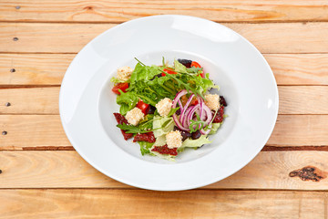 vegetarian salad with dried tomatoes and croutons on the wooden background