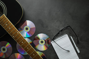 Guitar and accessories on a stone background. Desk musician, headphones, microphone.