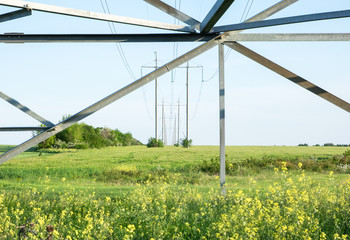Fototapeta na wymiar high voltage electric poles on green field