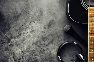 Fotobehang Guitar and accessories on a stone background. Desk musician, headphones, microphone. © alexkich