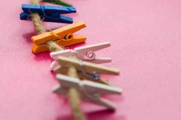 colored wooden clothespins hanging on a wire  