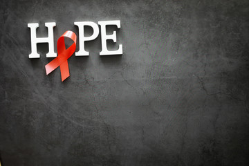 Symbol of human immunodeficiency virus disease. Red ribbon. A helping hand and support.
