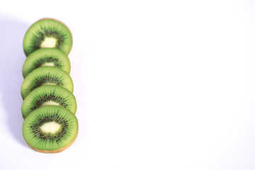 A kiwi fruit is sliced on a white background