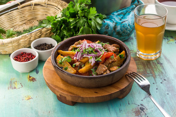 Meat stewed with vegetables in tomato sauce on blue wooden table