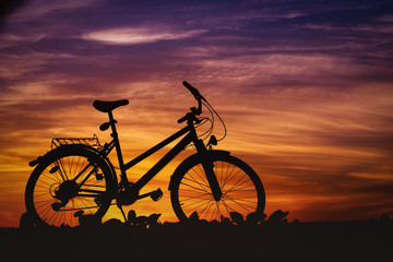 Silhouette of a bike on the background of the colorful sky at sunset