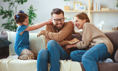 happy family mother father and child daughter laughing   at home
