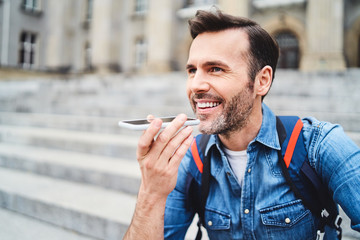 Man talking on phone with loudspeaker while out in the city