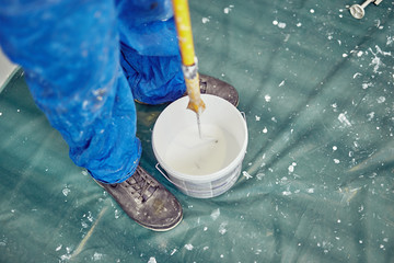 Worker painting walls inside the house - renovation fixes.