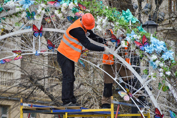 Fototapeta na wymiar Worker decorates the city for the holiday