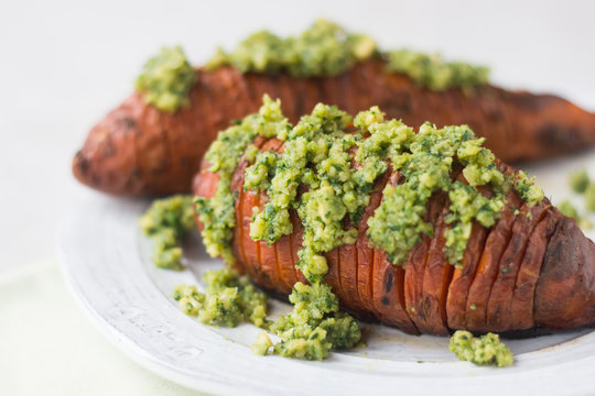 Hasselback Baked Sweet Potatoes Served With Green Walnut, Kale And Parsley Pesto On White Plate. Horizontal, Close Up, Copy Space.