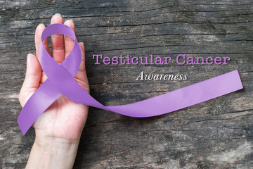 Testicular Cancer orchid color ribbon awareness on helping hand