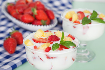 Homemade Strawberry and pineapple yoghurt with fresh fruit and mint leaves. Healthy food for breakfast.