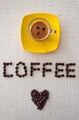 Closeup of expresso and coffee beans drawing a heart and the word Cafee.