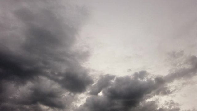 Spooky sky with dense dark nimbostratus clouds with multi-level layer and dramatic lights in timelapse